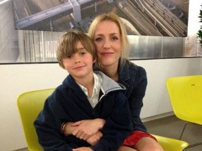 Gillian Anderson and Felix Griffiths is sitting in the same chair as Gillian is holding Felix.